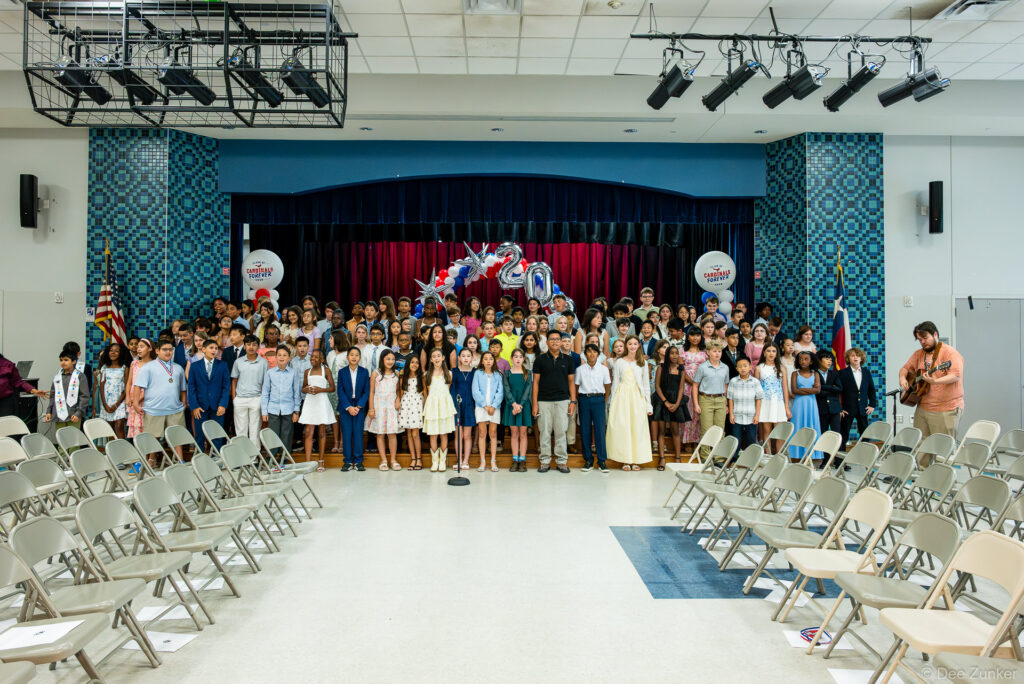 Horn Elementary 5th grade graduation class group photo on stage in school auditorium, Bellaire TX, 2026