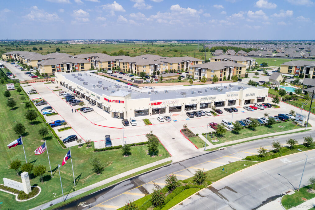 Drone aerial photo of retail strip center and apartment complex at 7035 West Grand Parkway South, Houston TX area.