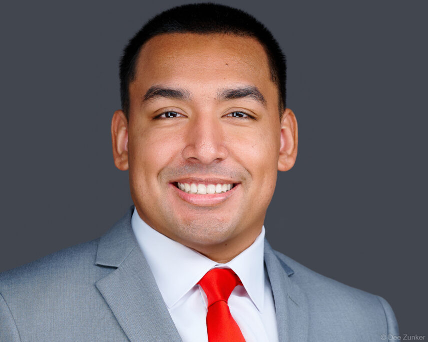 Professional male corporate headshot, gray background studio portrait, light gray suit and red tie, Houston commercial photography.