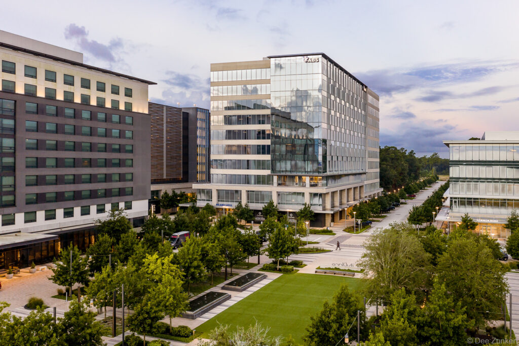 Early morning drone photo of a large landscaped courtyard in front of commercial office buildings in The Woodlands, TX.