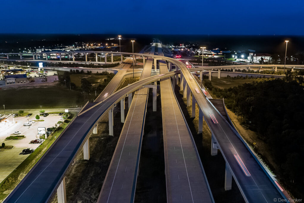 Aerial drone photo at twilight of the new Hwy 99 interchange over Hwy 59 North. Glowing street lights highlight the infrastructure.