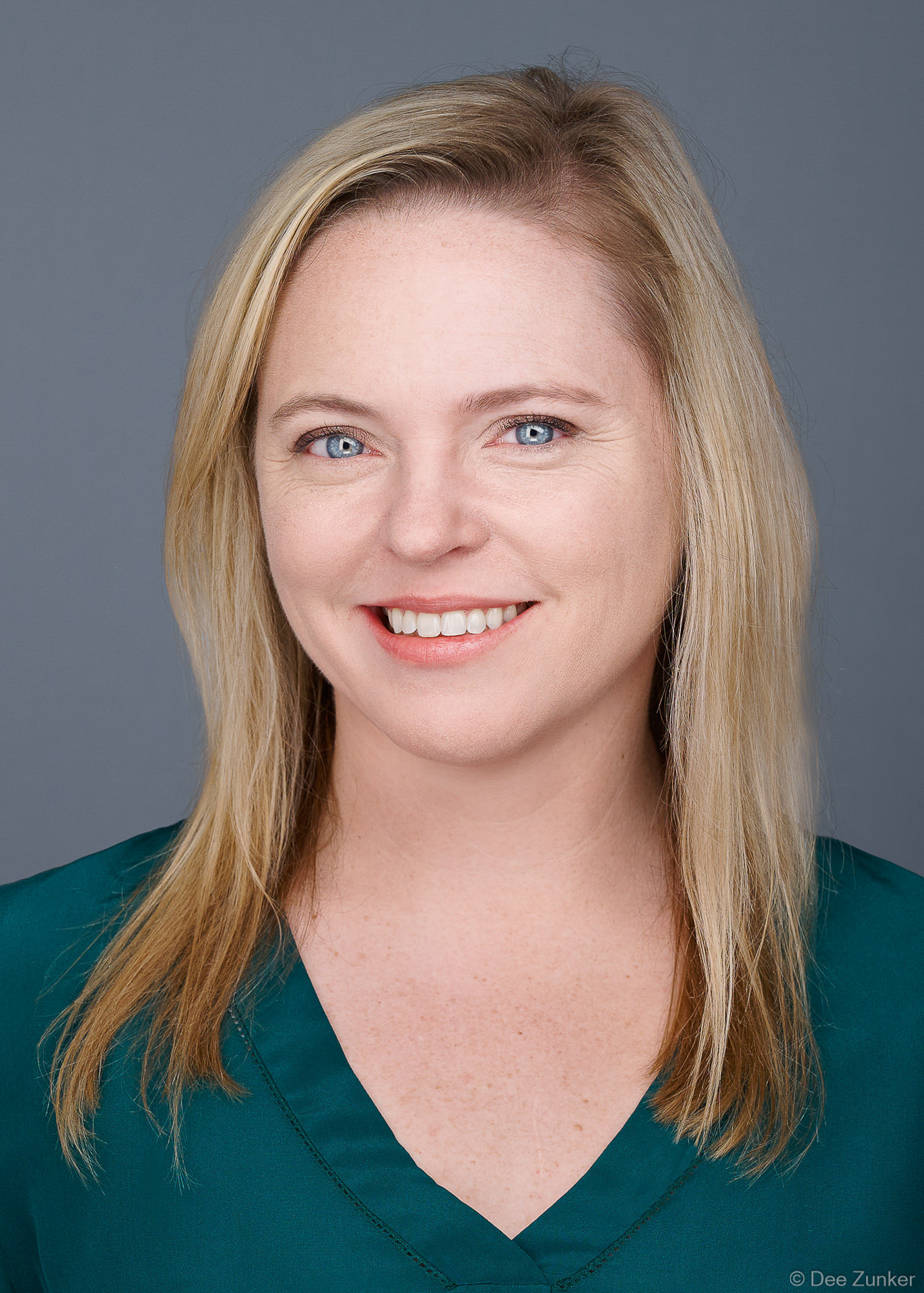 ERAS residency application headshot of a blonde woman in teal blouse, 5x7 format, photographed near the Texas Medical Center, Houston TX with light gray background.