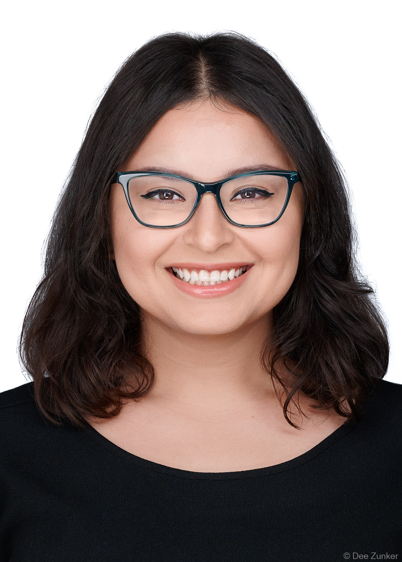 ERAS-compliant 5x7 medical residency headshot of a young woman with glasses, smiling, photographed near the Texas Medical Center, Houston with white background.