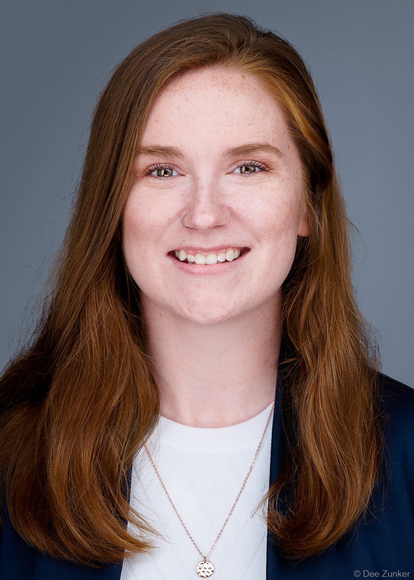 5x7 ERAS residency application headshot of a smiling woman with auburn hair near Texas Medical Center, Houston, TX with light gray background.