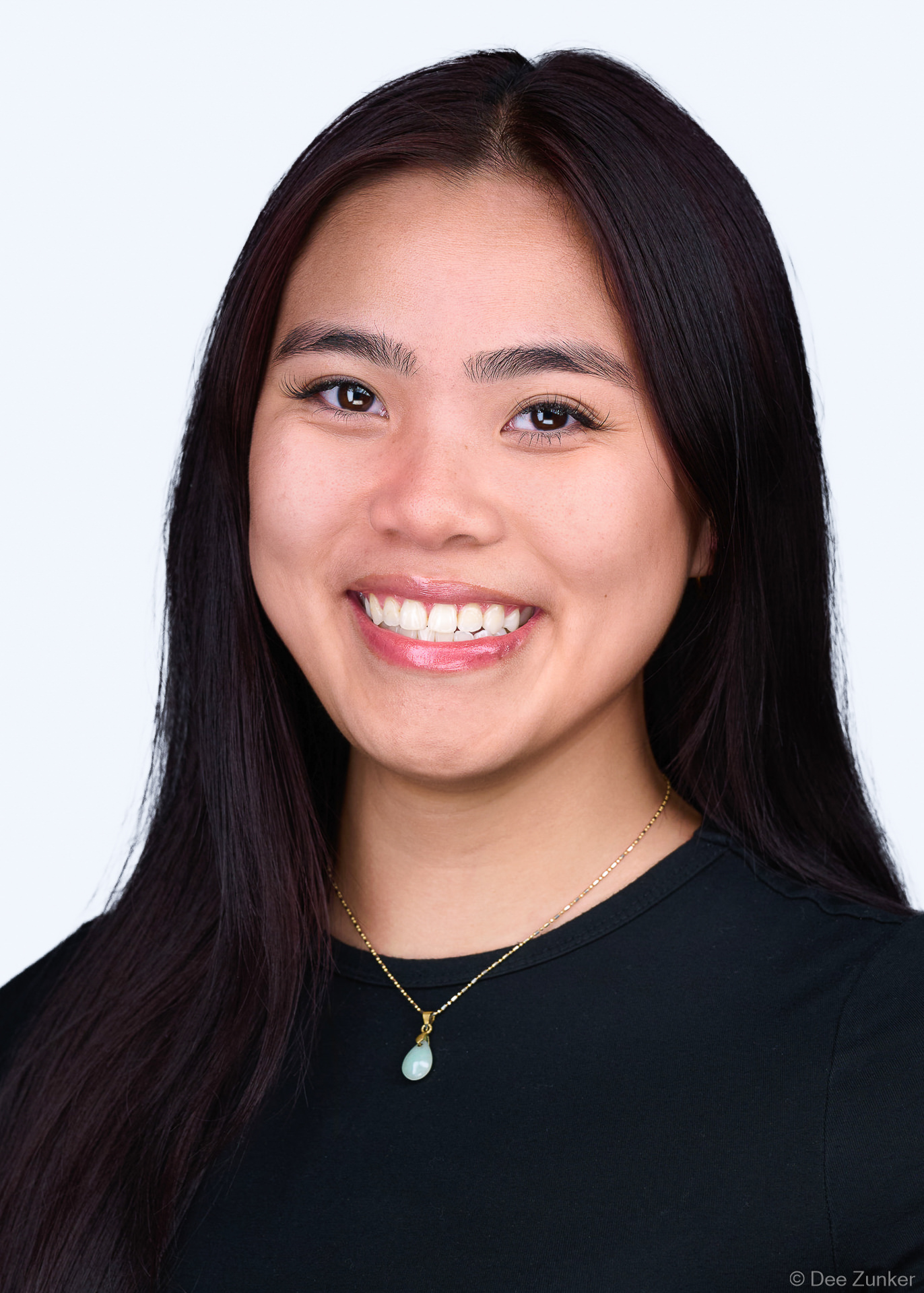 5x7 ERAS medical residency headshot of a smiling young woman with long dark hair, photographed in Houston near the Texas Medical Center with white background.