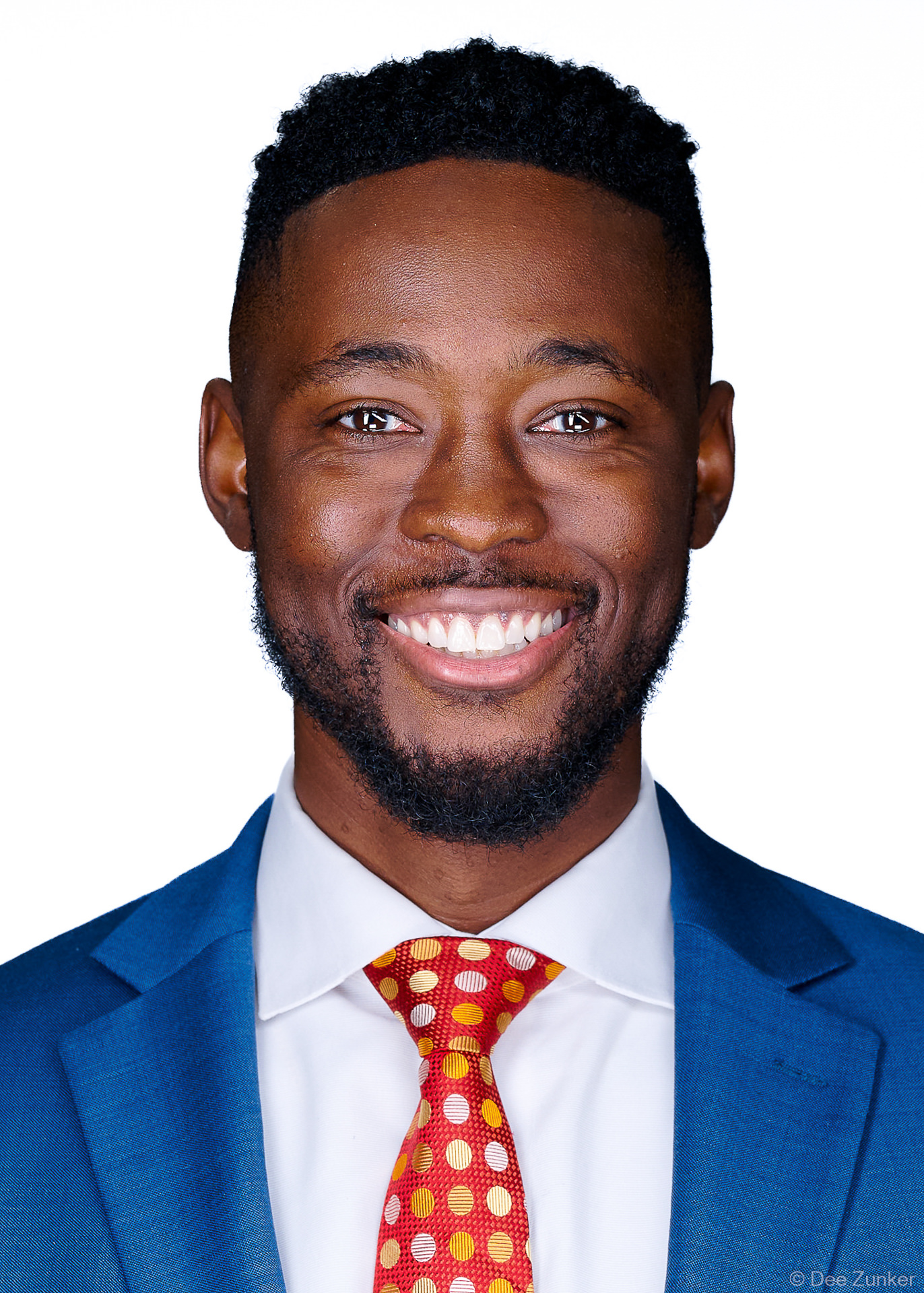 ERAS residency applicant headshot in 5x7 format, smiling man in blue suit and red tie, photographed near Texas Medical Center Houston with white background.