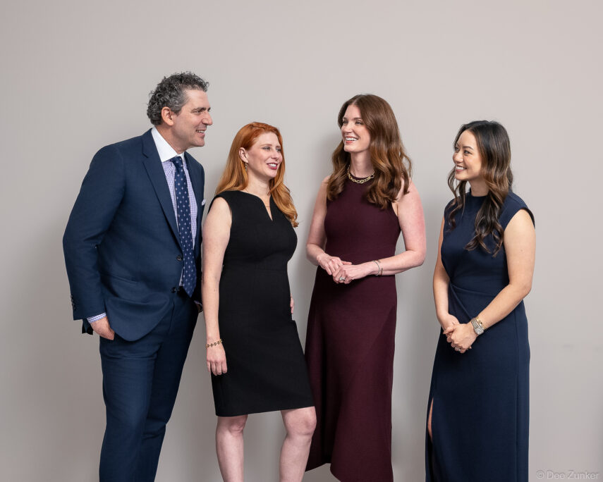 Four medical professionals in formal attire pose for corporate branding photography at Surgery Center in Houston TX.