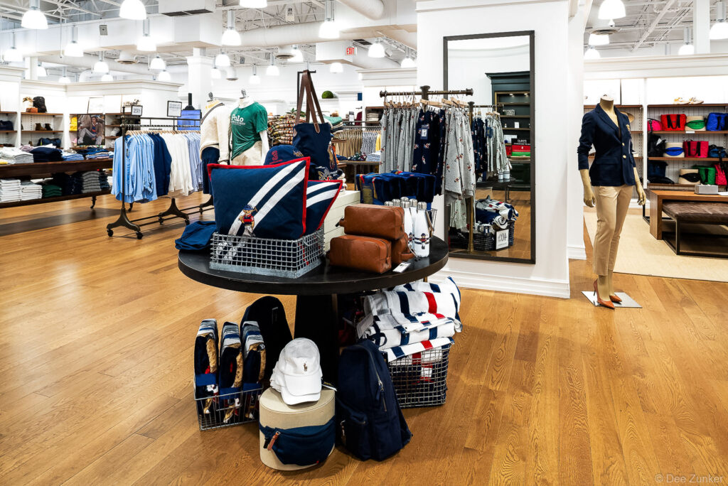 Polo Ralph Lauren store interior in Cypress TX showing apparel displays, accessories table, and mannequins in a bright retail space.