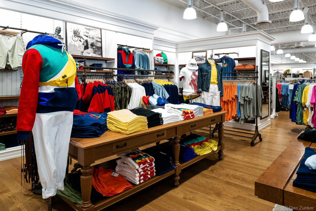 Colorful Polo Ralph Lauren menswear display with folded shirts and mannequin inside Cypress TX store, captured by Houston commercial photographer.