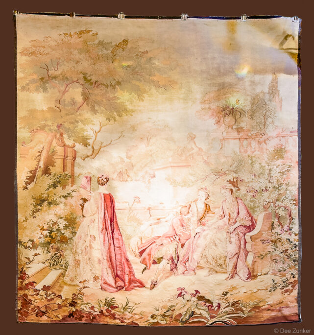 Faded Rococo-style tapestry depicting elegantly dressed figures in a garden scene, product photography by Dee Zunker Photography Houston.