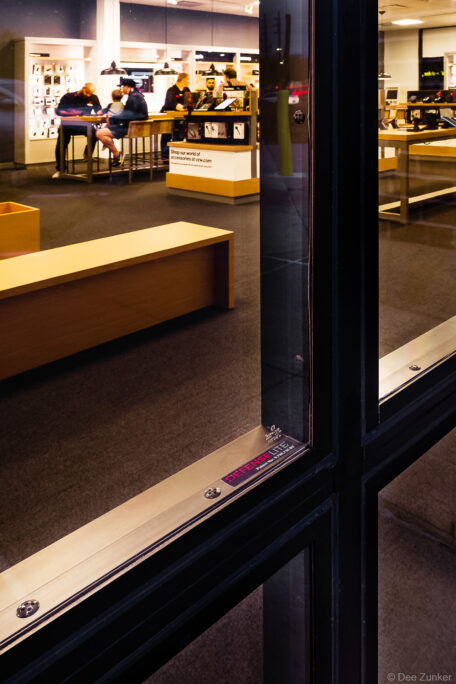 Close-up of DefenseLite architectural glass door panel at a Verizon retail store interior, Houston commercial photography.