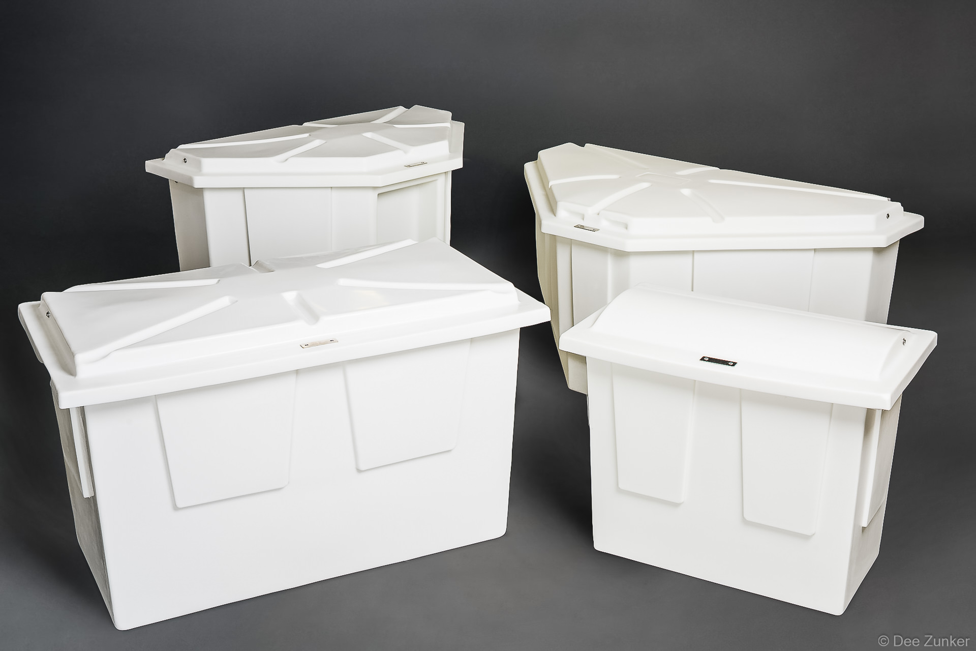 Four white polyethylene marine storage boxes with lids, varying sizes, arranged on gray background, Houston product photography.
