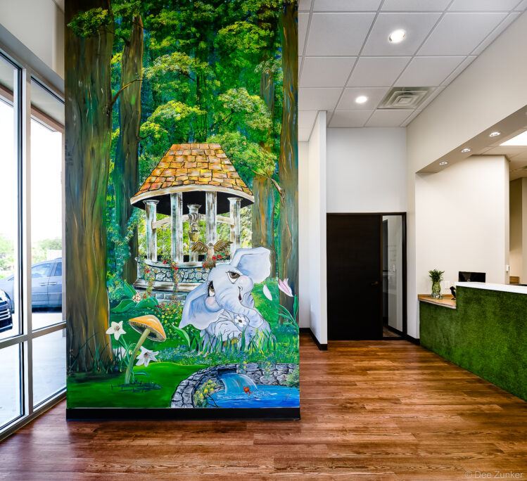 Vibrant jungle mural on office column featuring elephant and gazebo, photographed by Houston commercial interior photographer Dee Zunker.