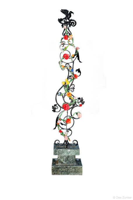 Wrought iron sculptural column with colorful painted roses and black eagle finial mounted on green marble tiered base, Houston product photography.