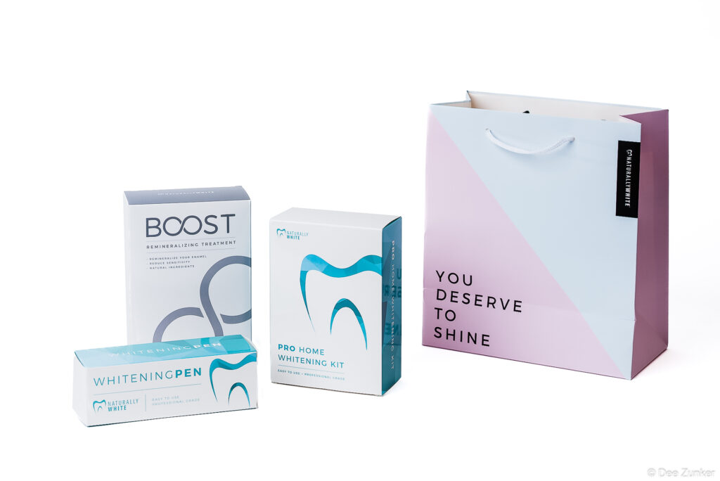 Houston product photography of Naturally White dental whitening kit, whitening pen, and Boost remineralizing treatment on white background.