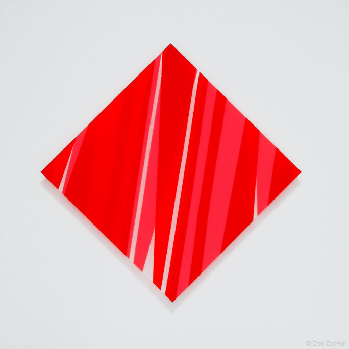 Red diamond-shaped canvas with diagonal red and pink stripes, retail product photography on white background by Dee Zunker Photography Houston.