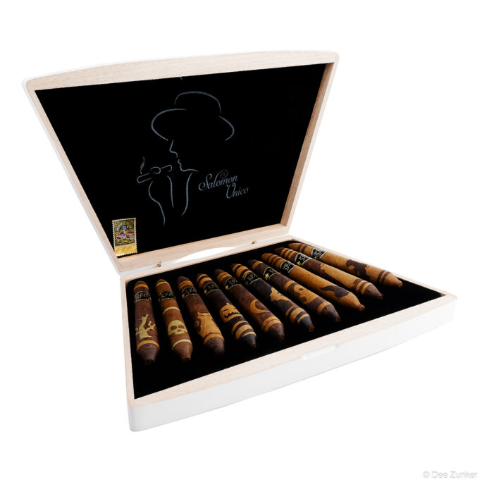 Open luxury cigar box displaying Salomon Unico branded cigars with decorative bands, shot on white background for retail product photography.