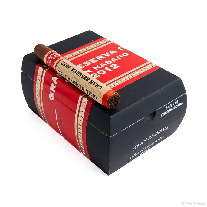 Gran Habano Gran Reserva 2012 Corona Gorda cigar resting on black and red retail box, white background product photography.