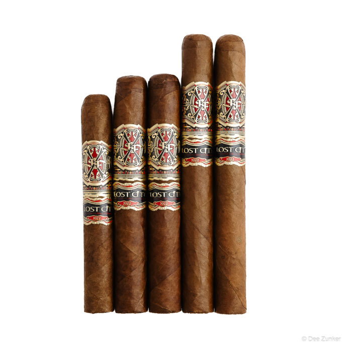 Five Lost City 2022 branded premium cigars arranged on white background, retail product photography by Dee Zunker Photography Houston.