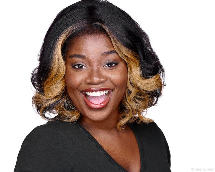 Smiling professional woman with ombre styled hair poses for a corporate studio headshot on a white background in Houston.