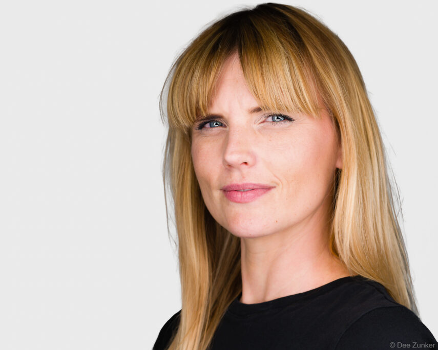 Blonde woman with blue eyes in a studio corporate headshot against a white background, captured for a Houston professional.