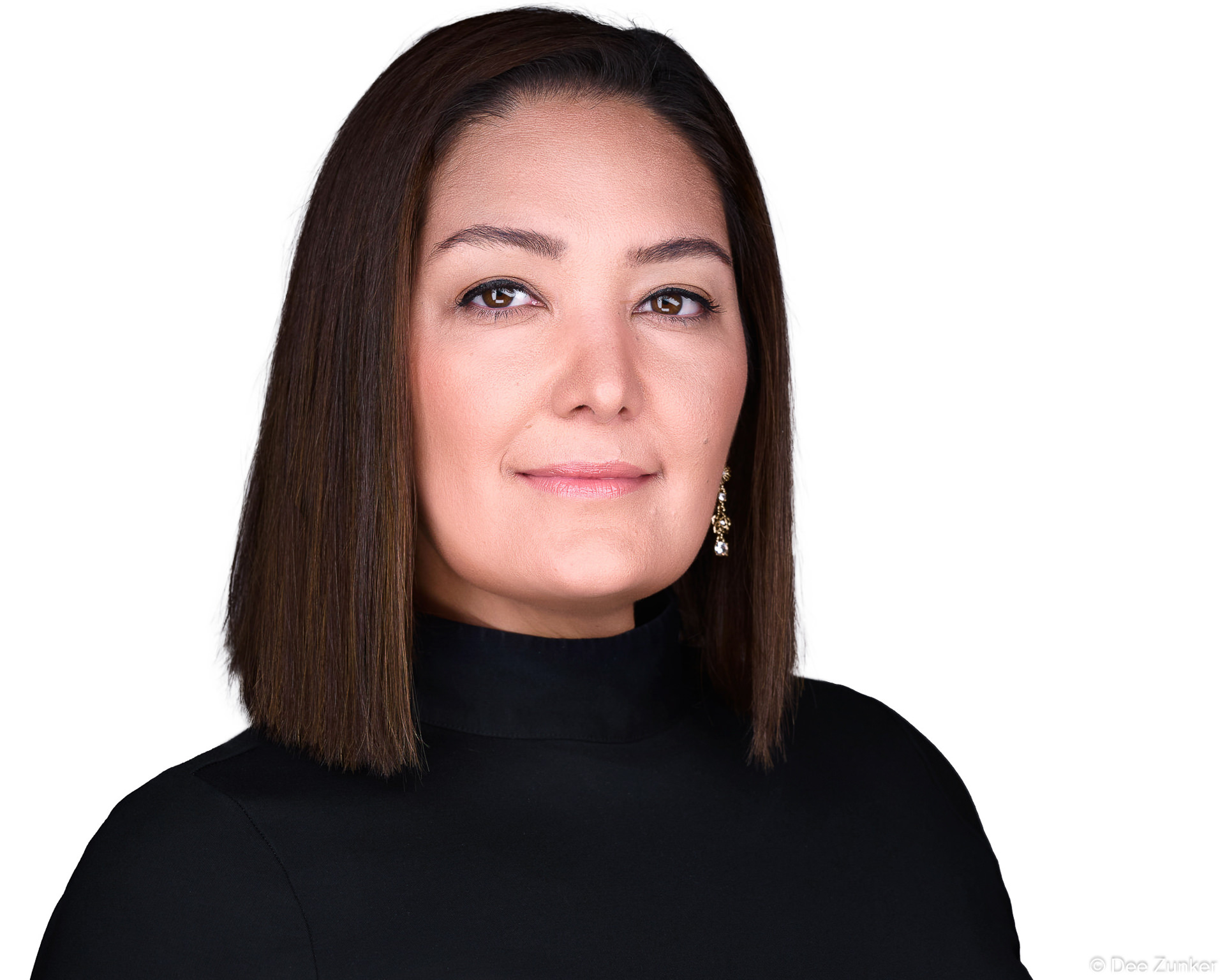 Woman in black turtleneck poses for a professional headshot against a white backdrop in a Houston studio, with soft studio lighting.