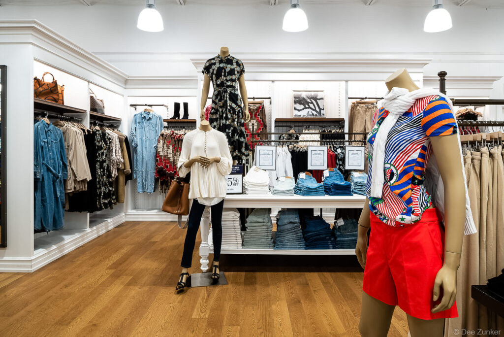 Bright Ralph Lauren store interior in Cypress TX featuring mannequins styled in colorful apparel alongside folded denim displays and clothing racks.