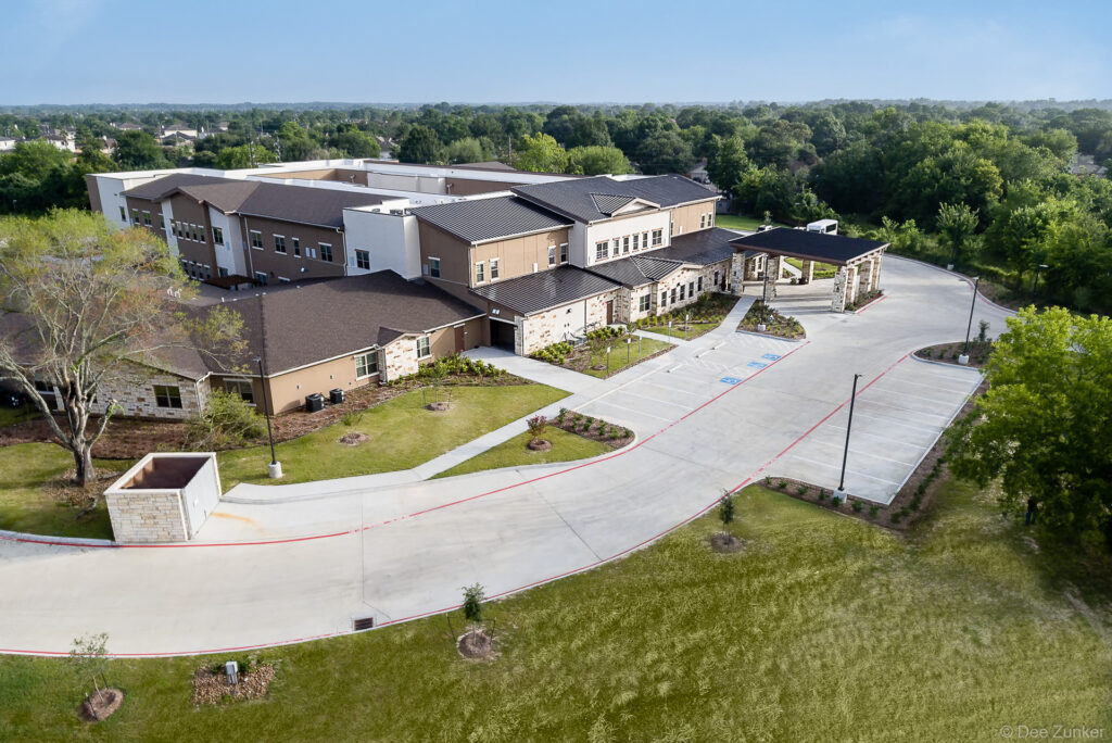 Late afternoon drone view of a senior care center architecture in Northwest Houston, highlighting the facility grounds.