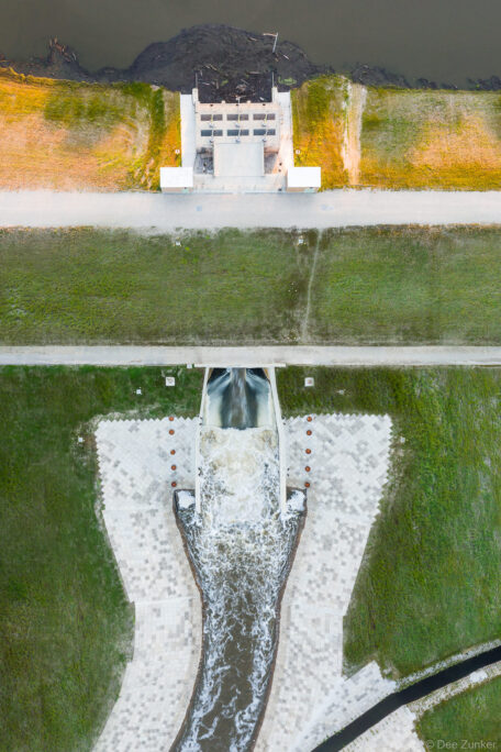 Aerial drone photo of Barker Reservoir flood control dam and spillway releasing water, shot from directly above, Houston, TX.