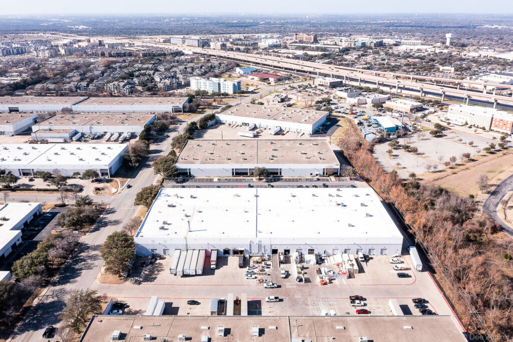 Drone aerial photo of large industrial warehouse complex with loading docks and parking lot in Dallas-area commercial district.