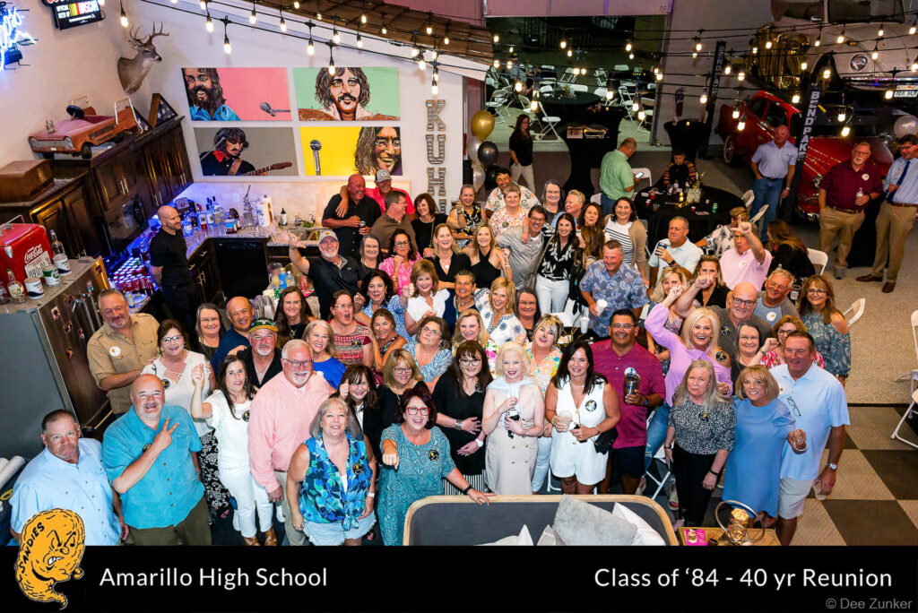 Large group of Amarillo High School Class of 1984 alumni gathered indoors for their 40th reunion, smiling and celebrating.