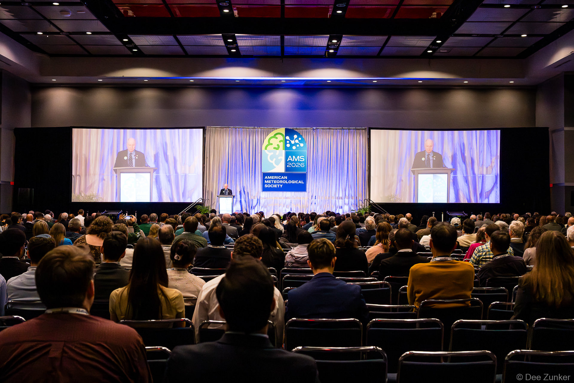 Large audience attends AMS American Meteorological Society awards ceremony with speaker at podium on conference stage in Houston TX.