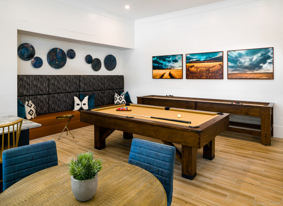 Apartment game room amenity featuring a pool table, shuffleboard, built-in banquette seating, and rustic decor in Katy Texas
