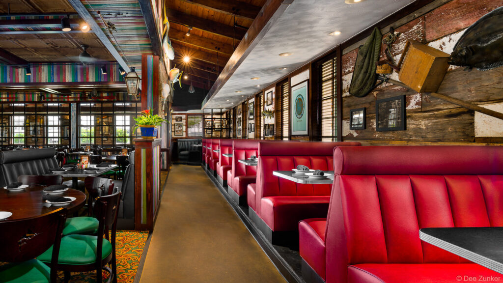Red vinyl booth seating and eclectic rustic decor inside a Katy TX seafood restaurant interior photographed professionally