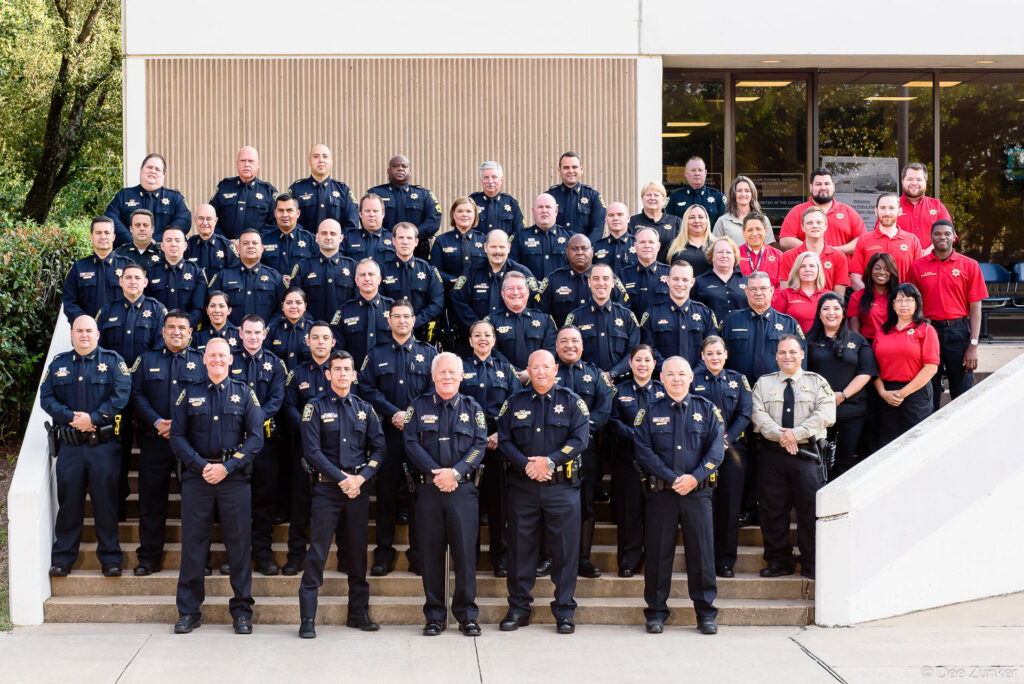 Large group portrait of Bellaire Police Department officers and staff in uniform on building steps in Houston, TX.