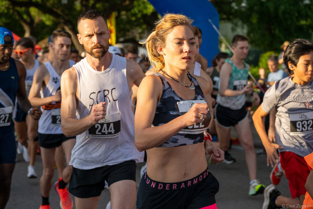 Runners compete at the Bellaire Trolley Run 5K race in Houston TX, captured at the crowded race start line.