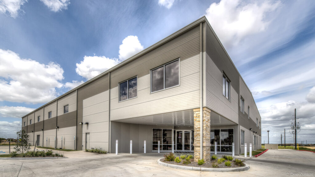 Exterior architectural photography of a two-story commercial gym building with stone accents and glass entrance in Richmond TX