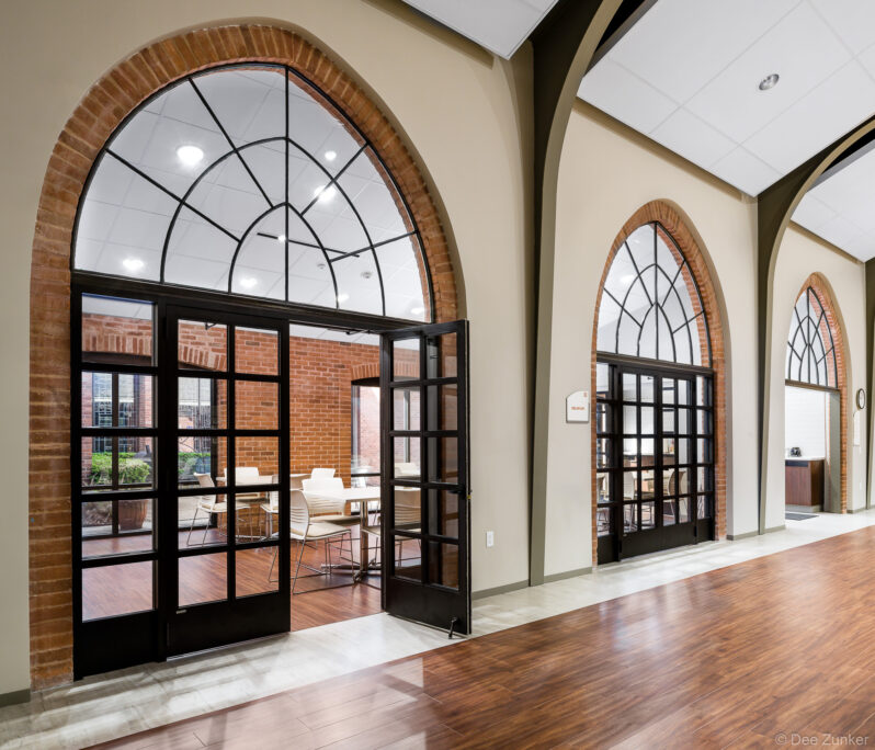 Architectural photo of the Calvary Episcopal Church community center. Glass doors for meeting rooms are framed by elegant architectural arches.