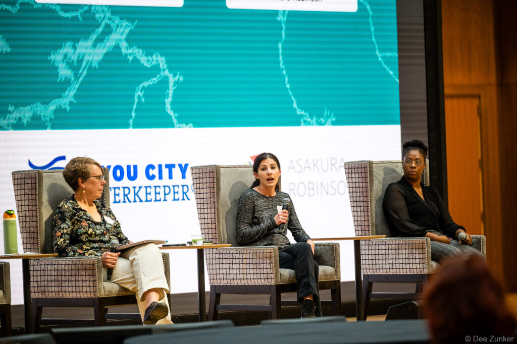 Three women panelists seated on stage during a corporate event panel discussion at a Houston conference