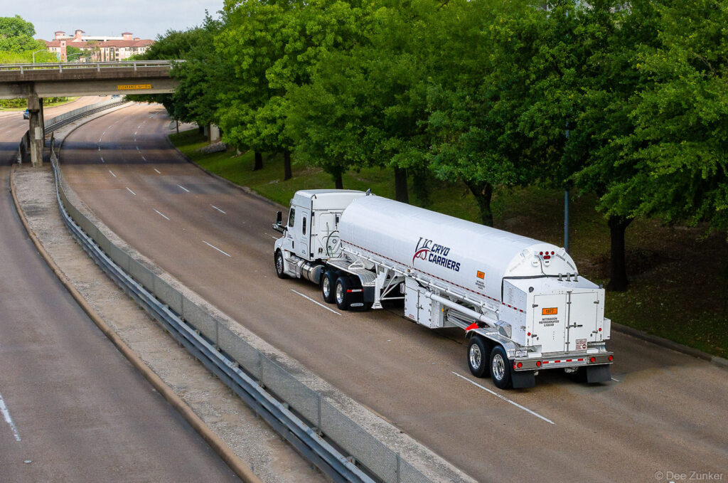 White cryogenic tanker truck carrying refrigerated nitrogen gas on a Houston highway, photographed for industrial transportation portfolio.