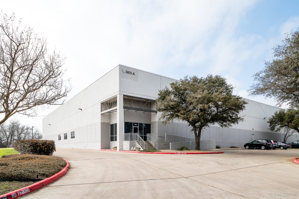 Exterior view of a gray tilt-wall commercial warehouse, Dallas TX, photographed for a real estate listing.