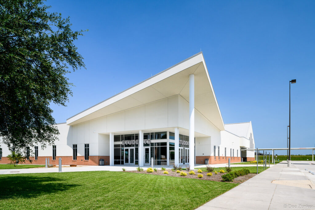Exterior view of a modern church student center in Spring TX featuring a dramatic angled white roof and glass entry facade