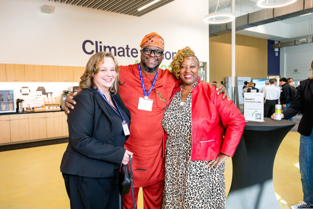 Three smiling conference attendees pose together at a climate innovation networking event inside Greentown Labs Houston.
