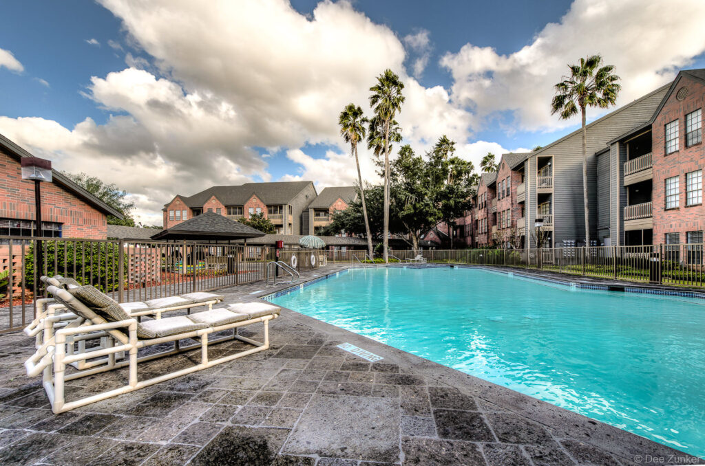 Outdoor architectural photo of a resort-style swimming pool area at a modern apartment complex in McAllen TX