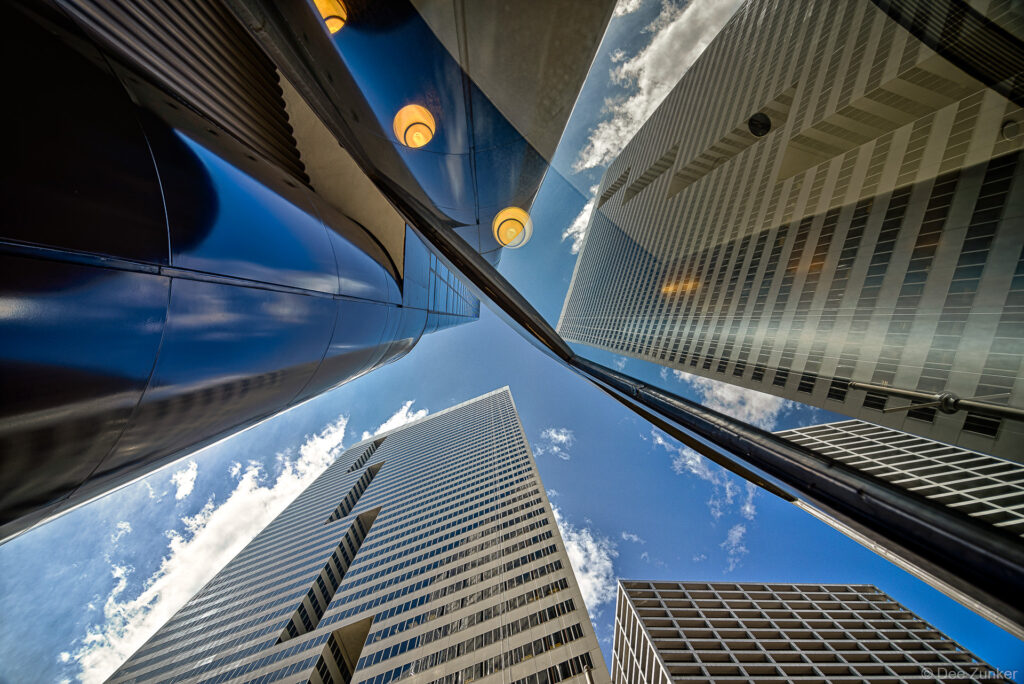 The First City Tower (circa 1981) reflects in the 2 Houston Center lobby. Those indentions in the First City Building are supposed to resemble “F’s”. Photo by Houston Architectural Photographer Dee Zunker