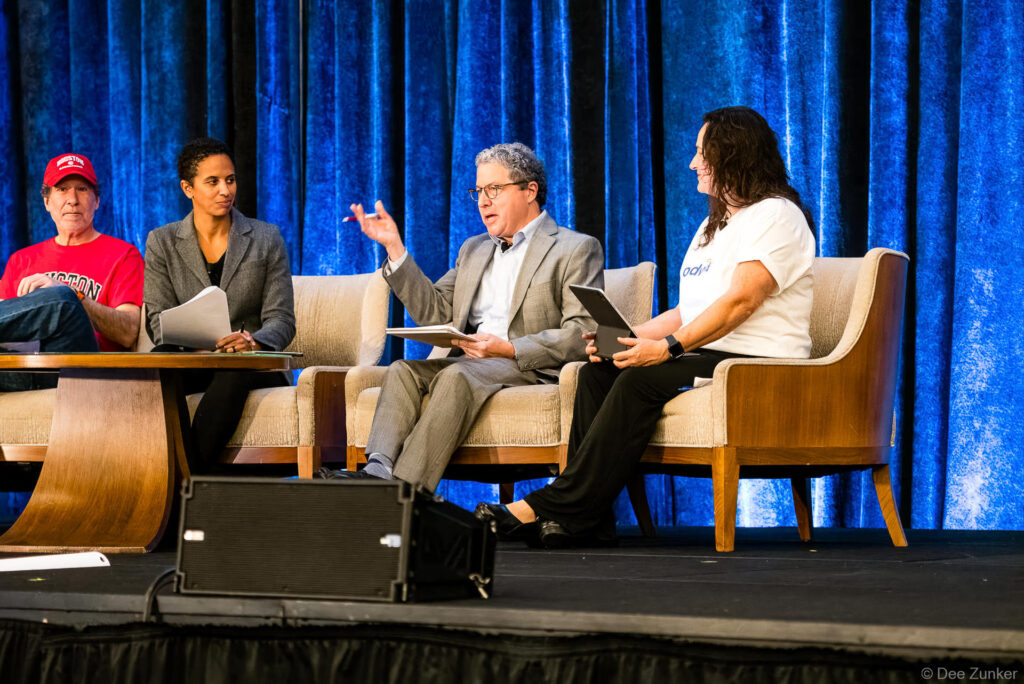 Four panelists seated on stage during a corporate leadership panel discussion at a Houston conference event