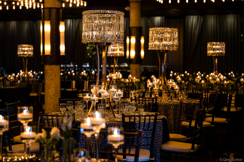 Elegant Houston corporate gala ballroom with crystal chandelier centerpieces, floating candles, and dramatic candlelit table settings