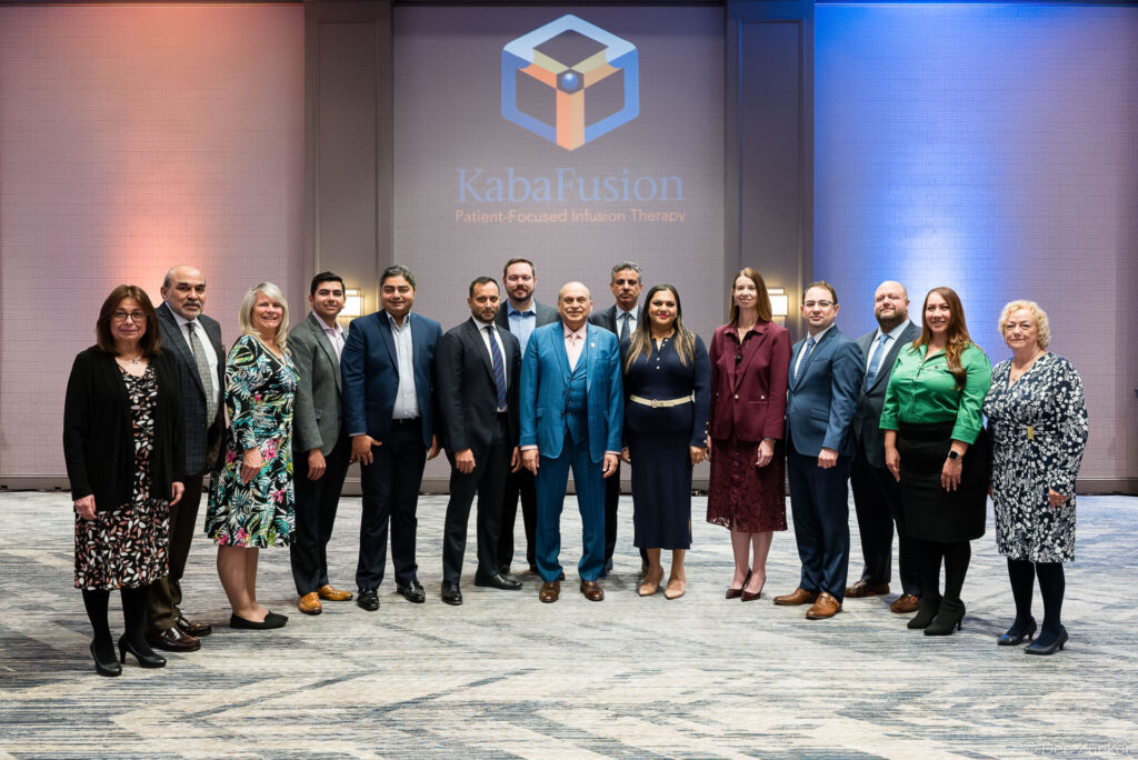 Group of fourteen healthcare professionals posing together at a corporate conference event in Houston, TX, photographed by Dee Zunker Photography.