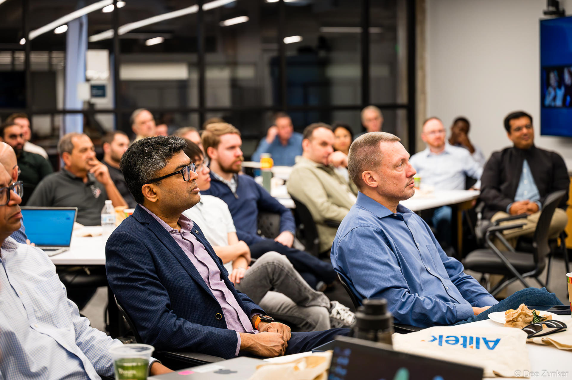 Houston corporate meeting attendees seated at tables listening attentively during a professional business presentation event