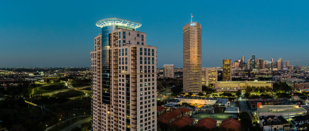 Drone aerial panorama of Houston skyline at dusk showing high-rise towers, Galleria area, and downtown in the background.